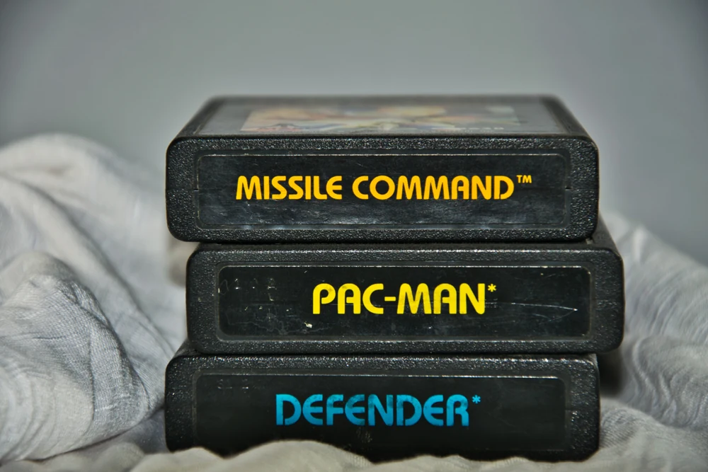 Cartucho Missile Command no topo de um conjunto que também contém Pac-Man e Defender.